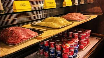 A deli counter with various meats, cheeses, and packaged goods.