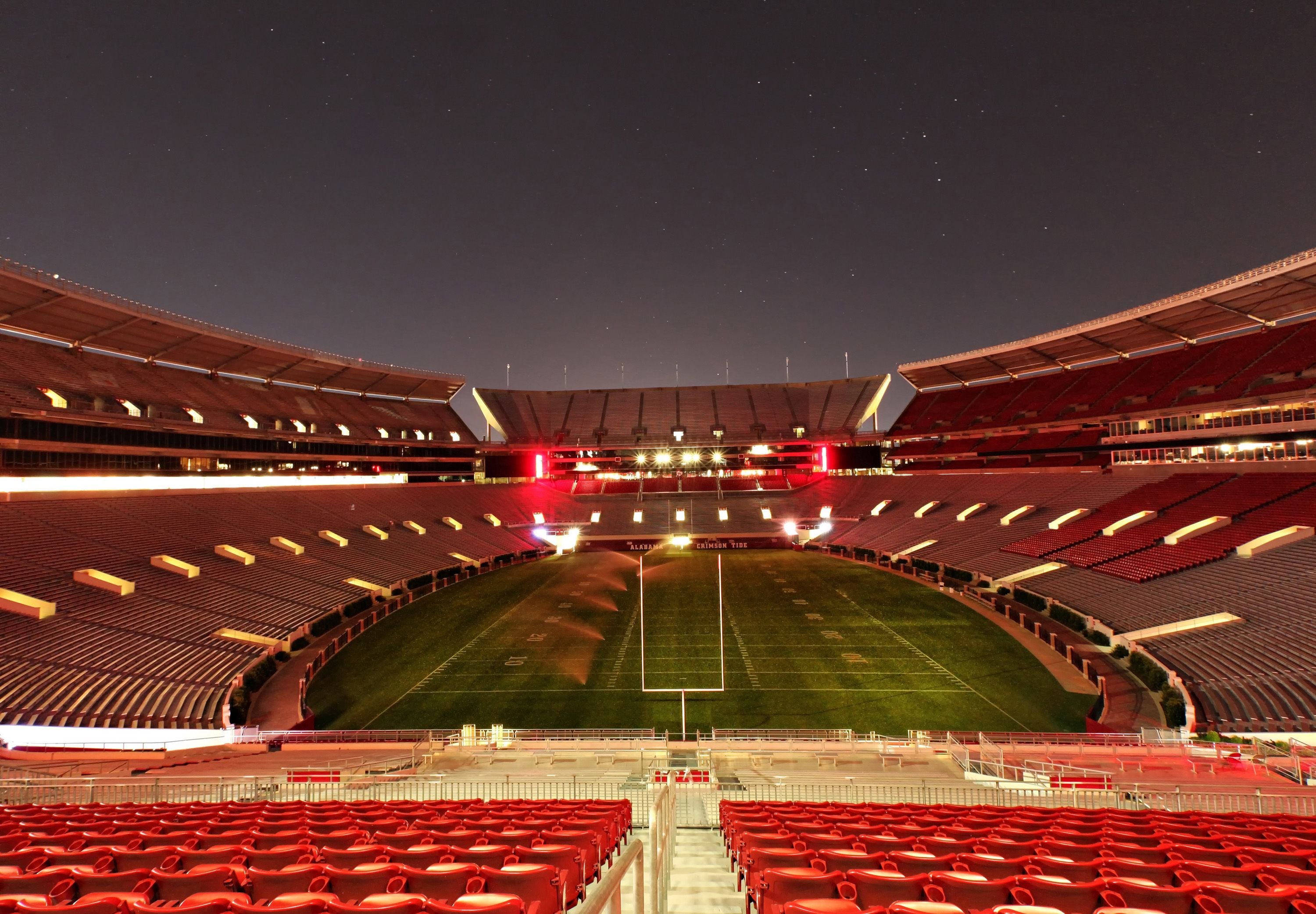 Un grande stadio vuoto con gradinate a più livelli e un campo centrale.