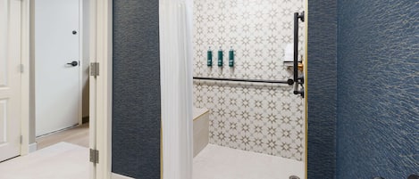 Un baño moderno con ducha, toallero y retrete.