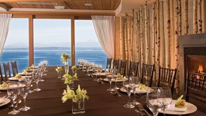 Una mesa de comedor lista para una comida, con vista al mar y a las montañas.