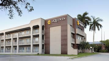 Ein mehrstöckiges Hotel mit Balkonen und einem gut sichtbaren 'LA QUINTA'-Schild.