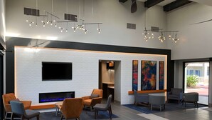 Un lobby moderno con chimenea, zona de estar y obras de arte.