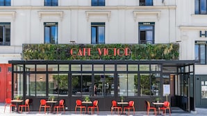 A cafe with a glass enclosure, red chairs, and a sign reading "CAFE VICTOR". - Best Western Plus Hôtel de Dieppe 1880 (Rouen)
