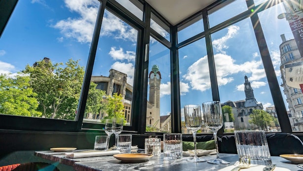 A table set with glasses and plates, overlooking a cityscape with historic buildings and a clock tower. - Best Western Plus Hôtel de Dieppe 1880 (Rouen)