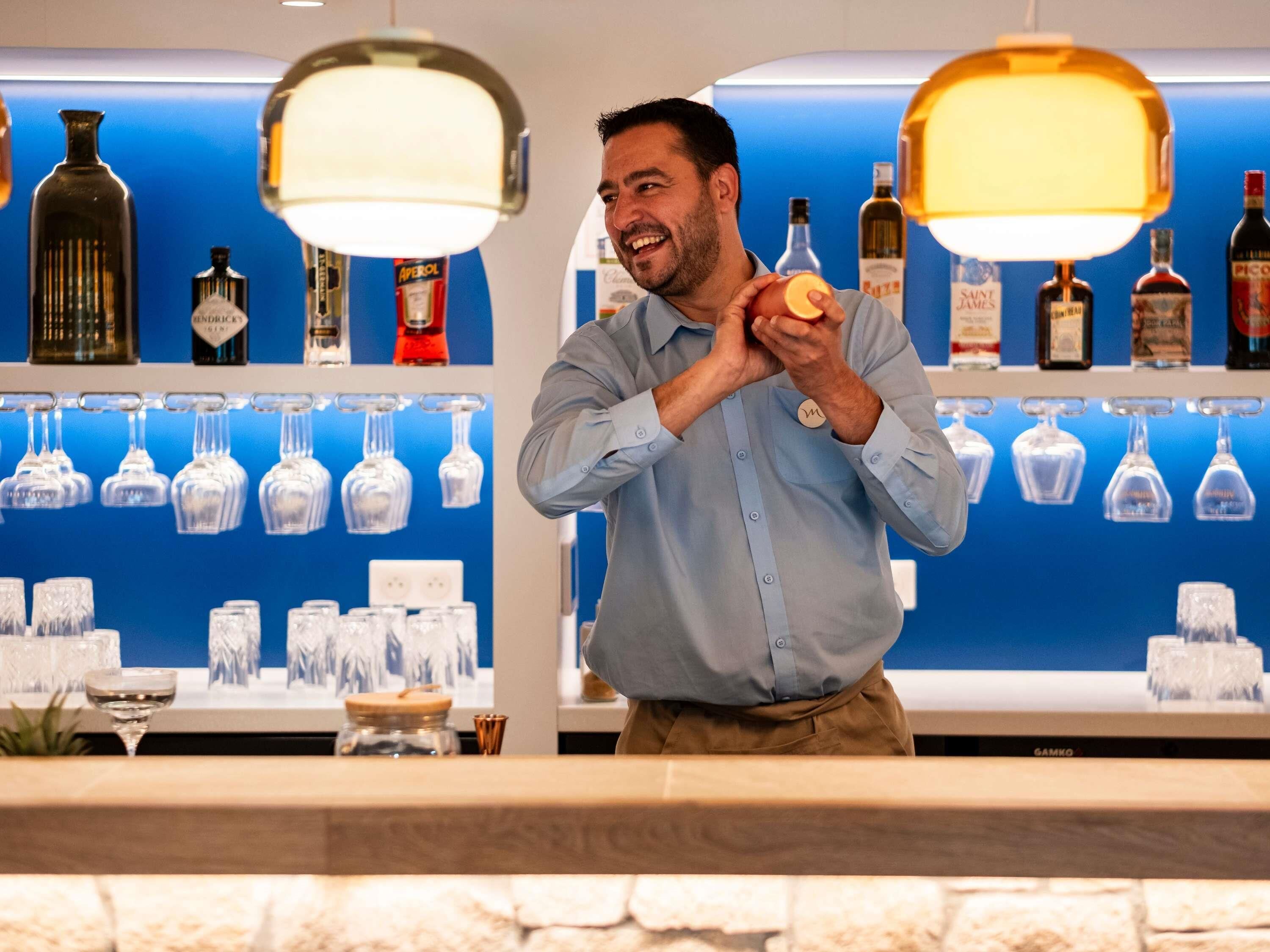A bar area with shelves of liquor bottles and hanging glassware.