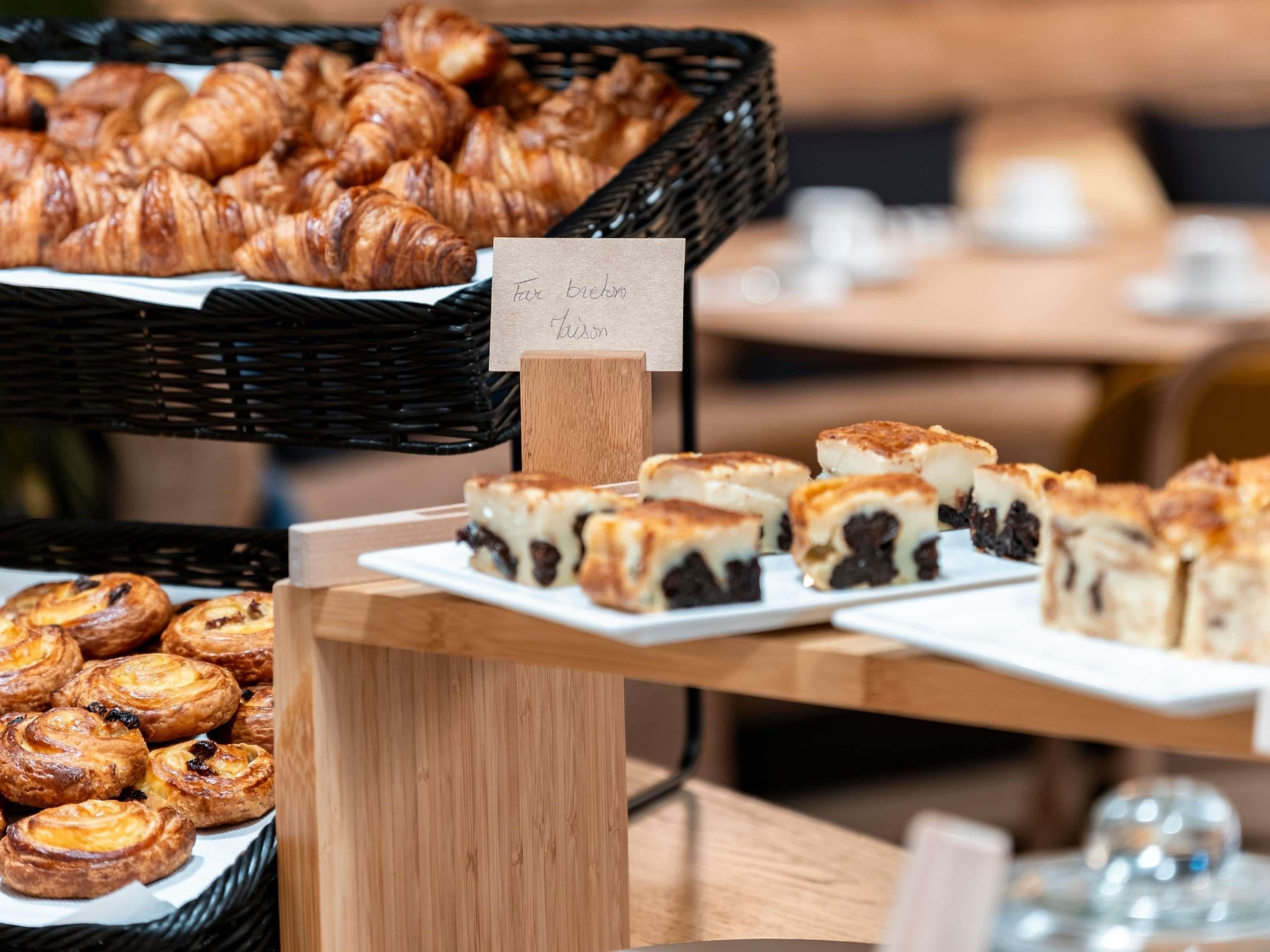 A display of pastries including croissants and a sign indicating a break room.