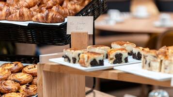 A display of pastries including croissants and a sign indicating a break room.
