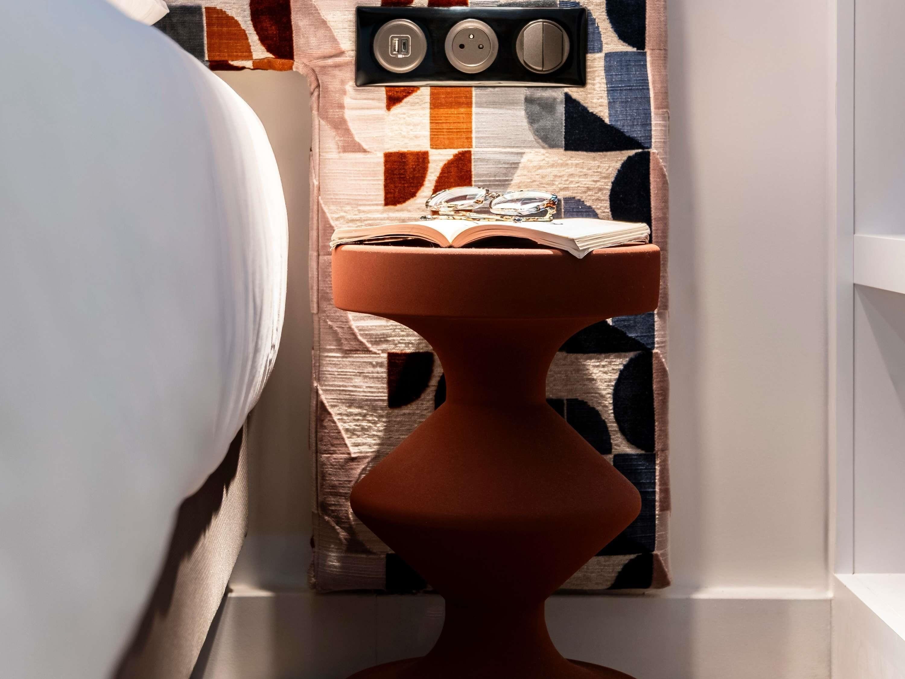 A bathroom with a modern toilet, a towel rack, and a patterned wall.
