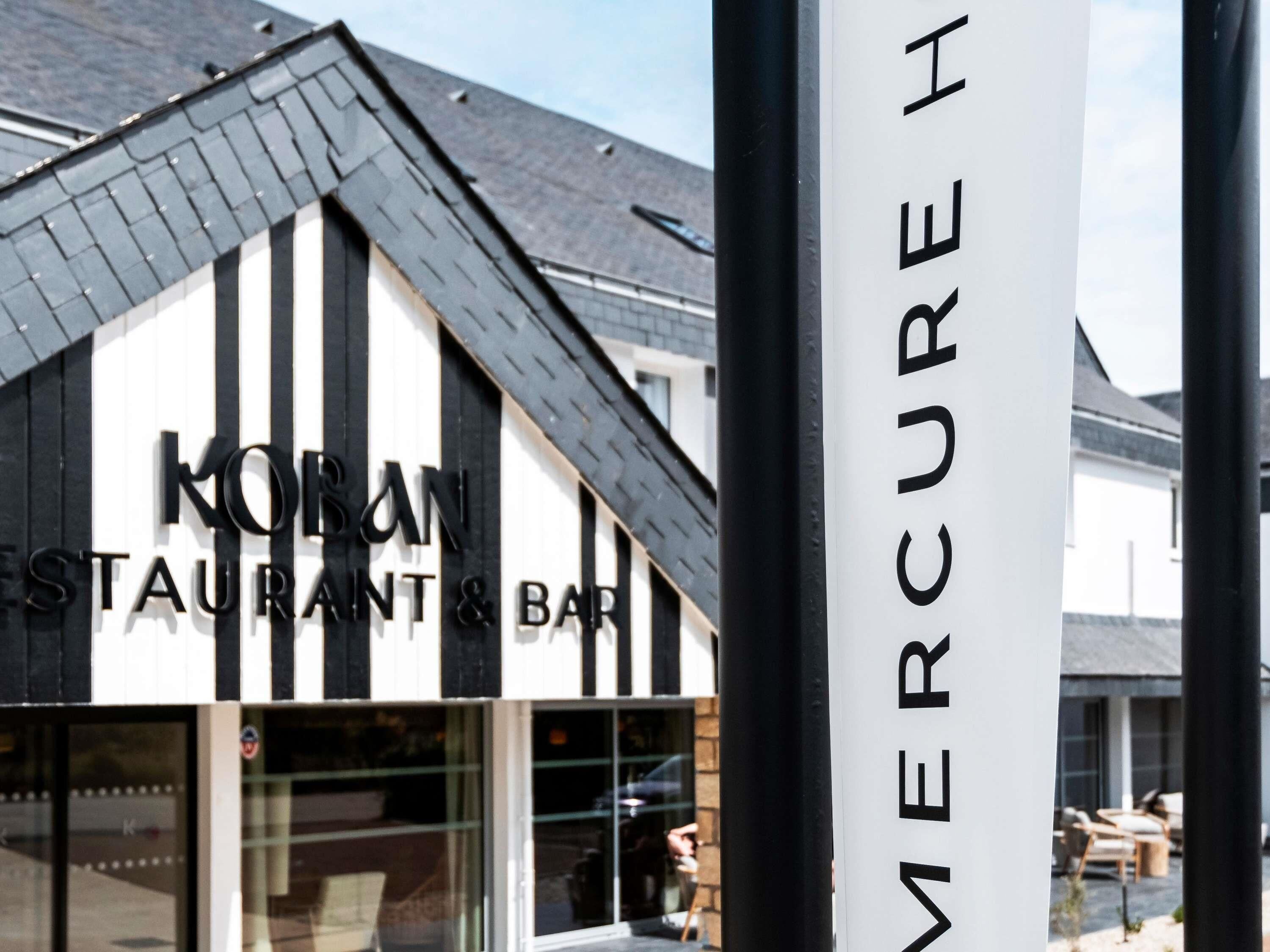 A building with a sign that reads 'KOBAN RESTAURANT & BAR' and a vertical sign with 'MERCURE H' visible.
