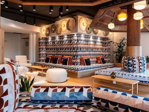 A modern interior with a patterned wall, seating area, and pendant lighting. - Mercure Quiberon Hotel & Spa (Quiberon)