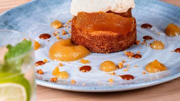 A dessert with caramel and a scoop of ice cream on a plate.