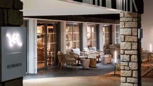 A restaurant with a modern design, featuring large glass doors and a stone pillar. - Mercure Quiberon Hotel & Spa (Quiberon)