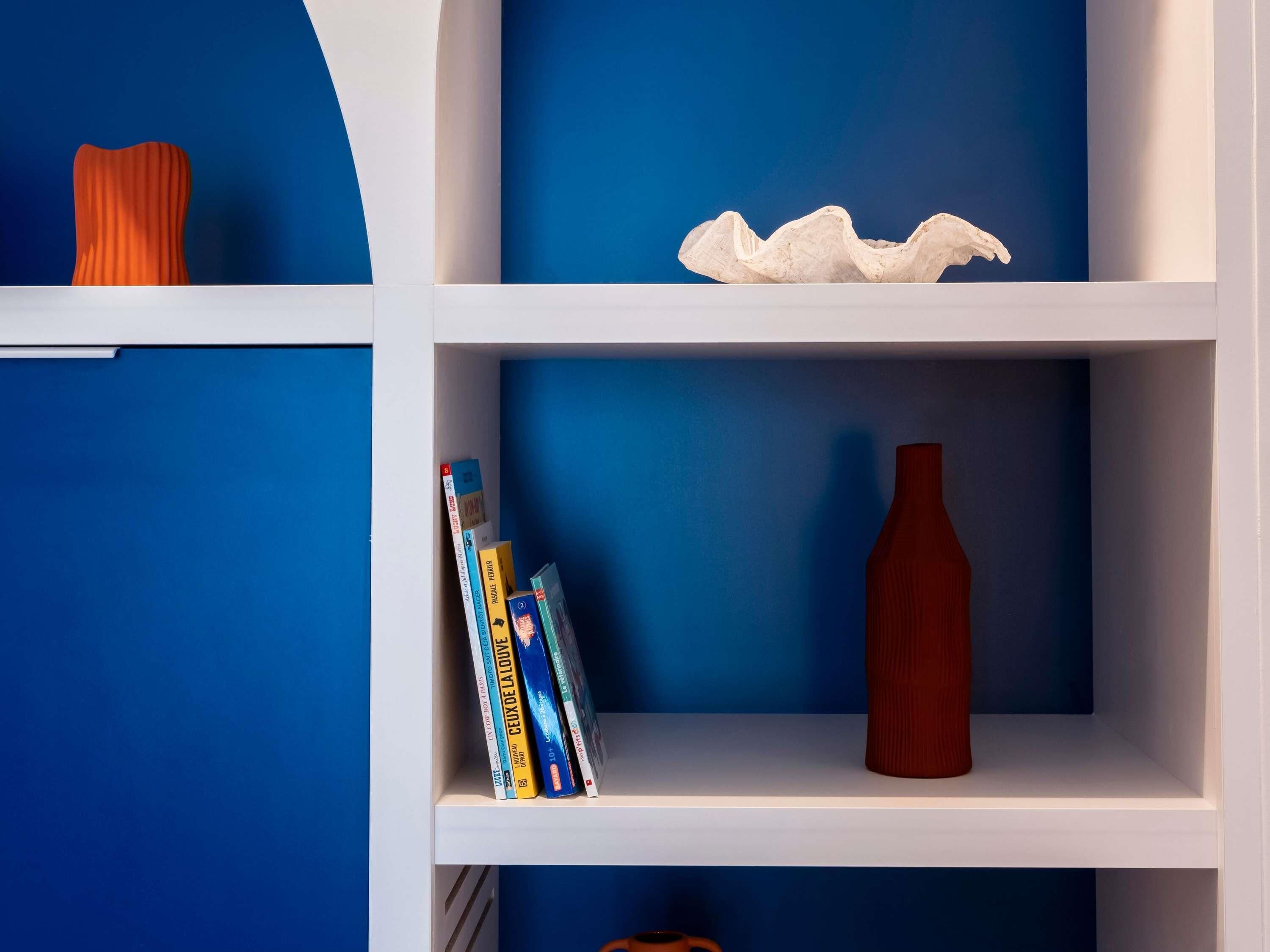 Una estantería con libros y objetos decorativos.