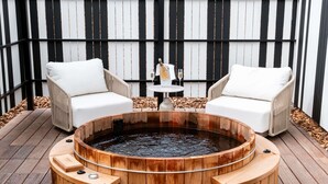A wooden hot tub surrounded by two white chairs on a wooden deck. - Mercure Quiberon Hotel & Spa (Quiberon)