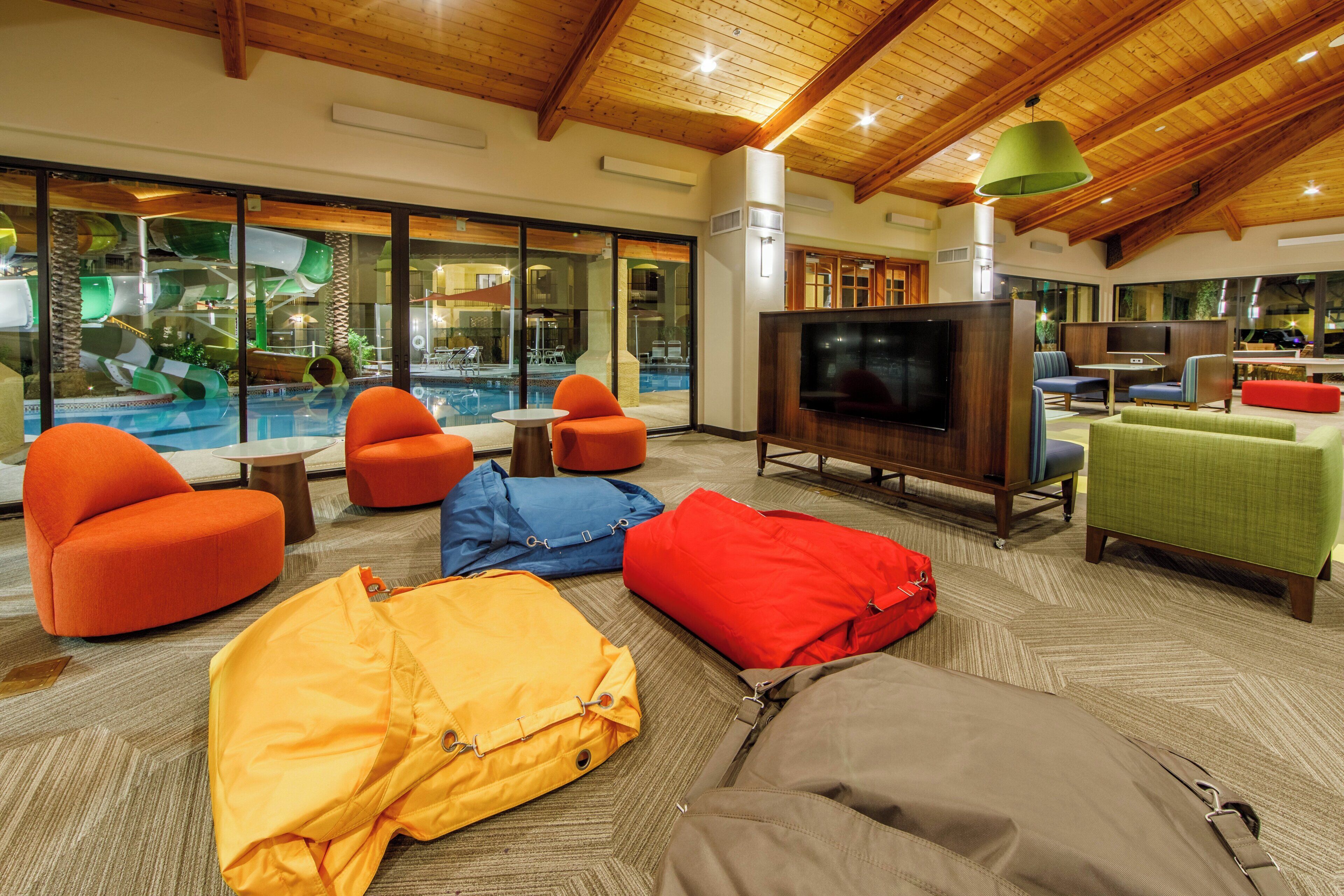 A spacious indoor area with a pool view, comfortable seating, and a television.