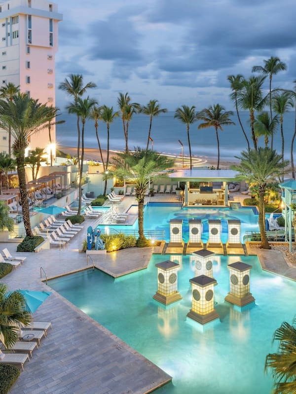 2 albercas al aire libre y sombrillas en la alberca