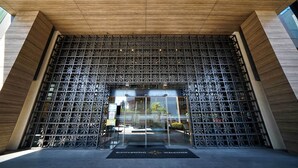 Fachada de metal con diseño geométrico y techo de madera.