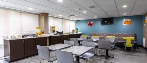 Un restaurant moderne doté d’un comptoir, d’un espace salon et d’un téléviseur fixé au mur.