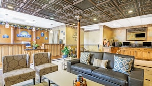 Le hall d’un hôtel Days Inn, avec un comptoir d’accueil, un espace salon et une kitchenette.