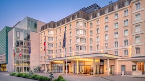 Un hotel con fachada moderna, varios pisos y una entrada destacada con el letrero "Sheraton Grand".