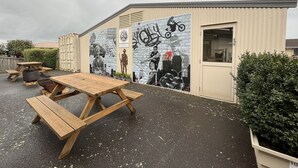 An outdoor area with a picnic table and a mural on the building. - Seasonal South Motel & Function Centre (Ulverstone)