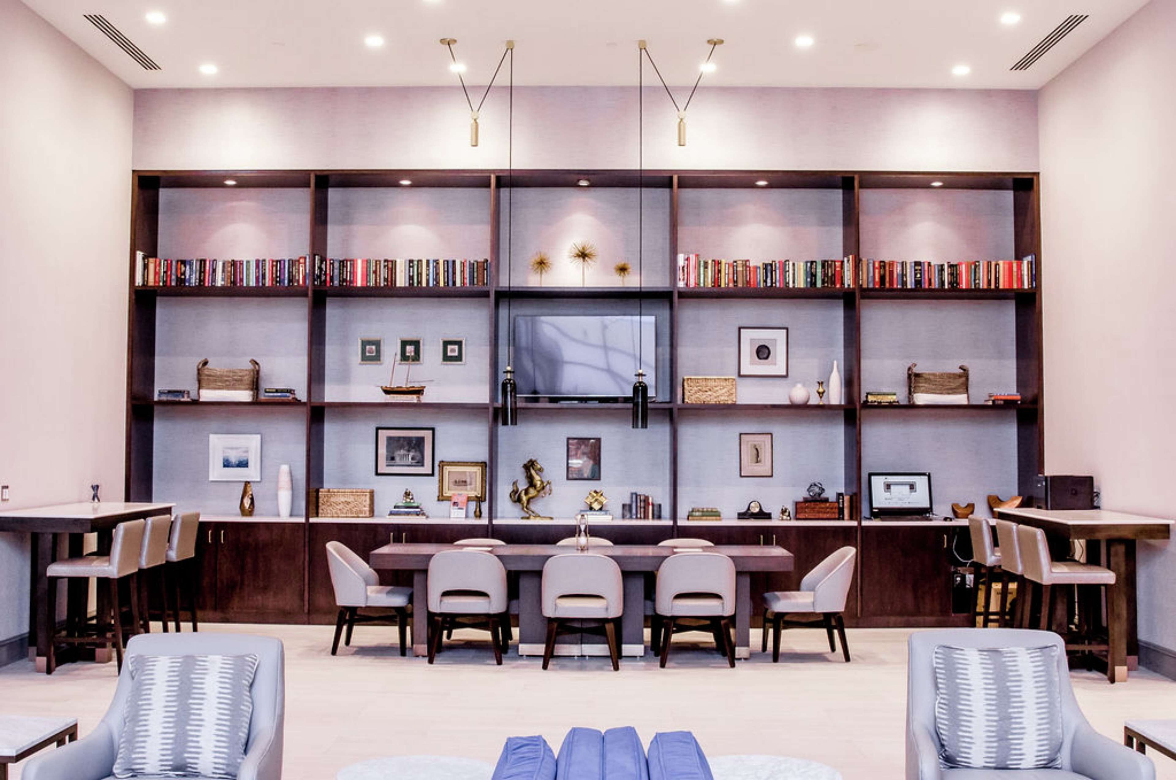 Una biblioteca moderna con estanterías, un comedor y asientos.