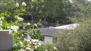 A residential area with a house, lush greenery, and a concrete structure. - Walmer Lodge Apartments (Bridgetown)