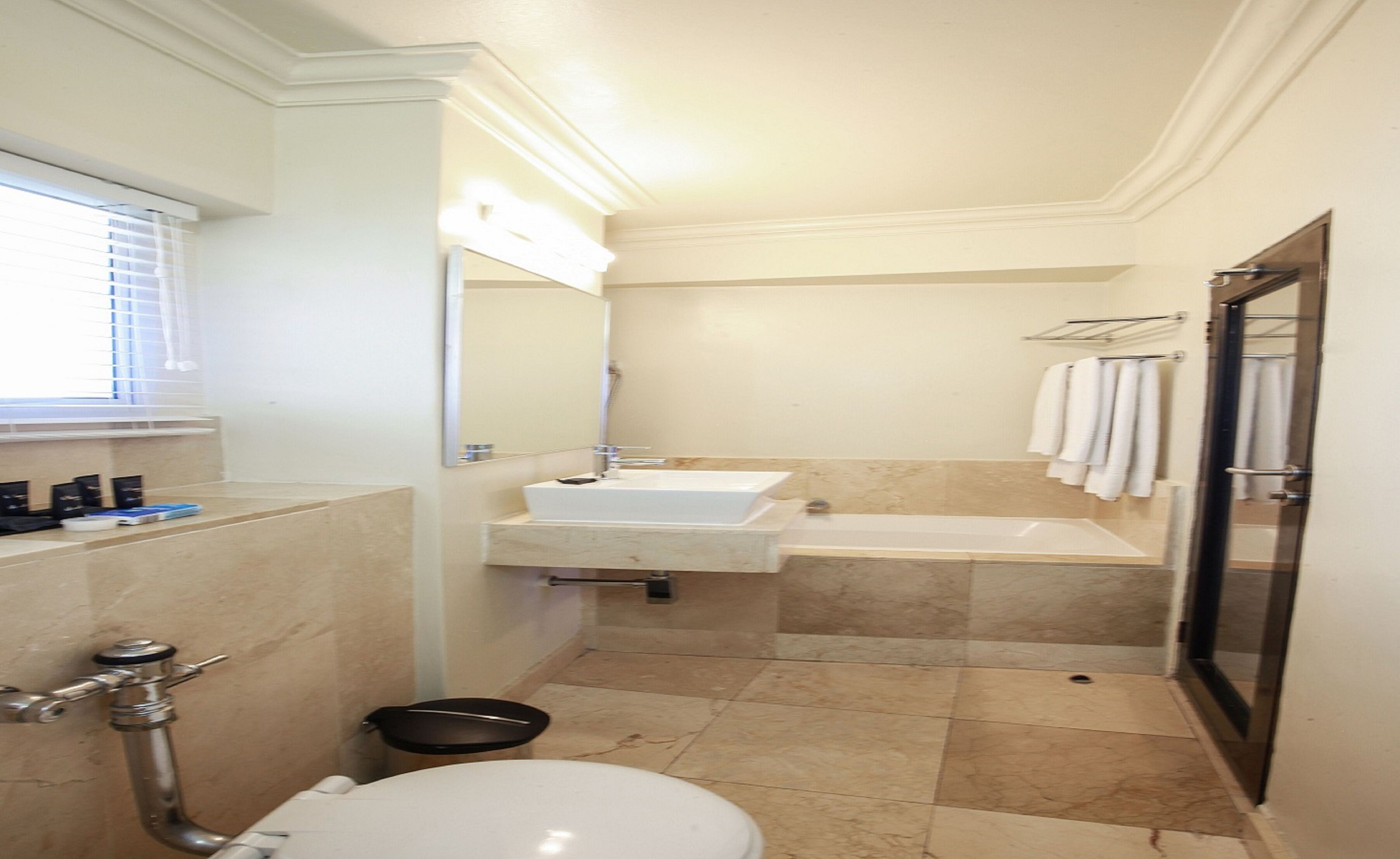 A compact bathroom with a toilet, sink, and shower area.