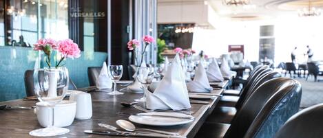 A restaurant setting with tables set for dining, including plates, cutlery, and napkins.