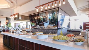 A buffet setup with various food items and a large mirror reflecting the room. - The Blue Waters Hotel (Durban)