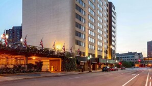 En modern hotellbyggnad med en tydlig skylt som visar att det är ett DoubleTree Suites by Hilton-hotell.