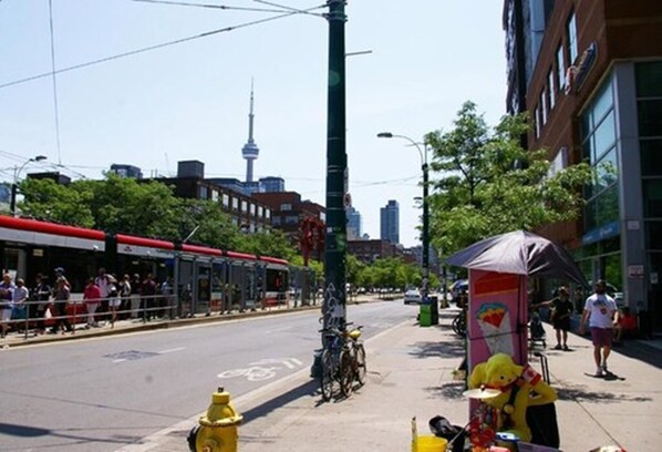 A street scene with a yellow fire hydrant, a tram, and a person in a yellow costume.
