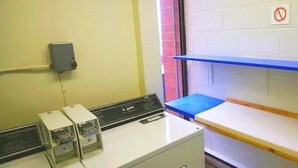 A laundry area with a washing machine, a dryer, and a blue table.