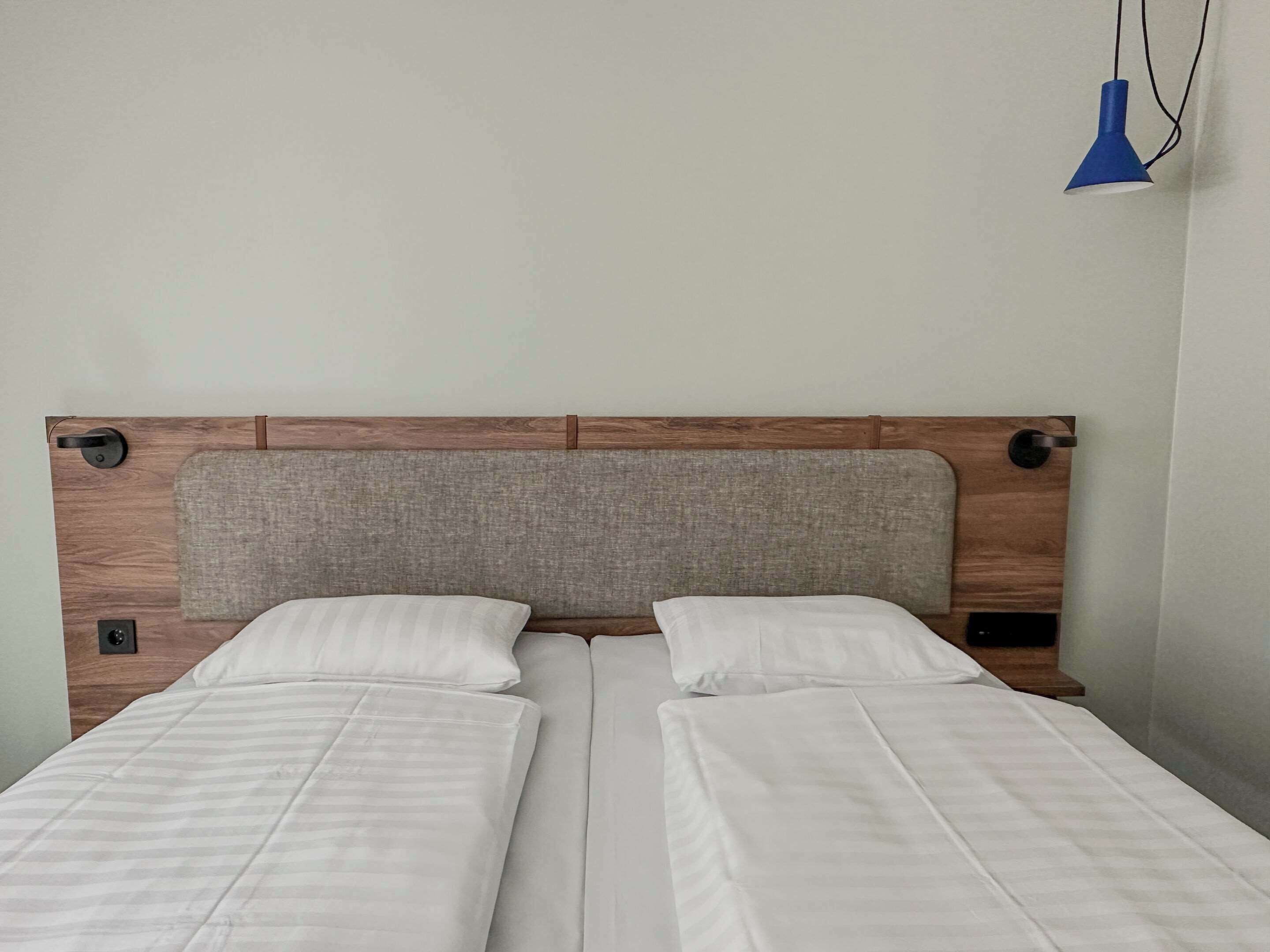 A double bed with a wooden headboard and two pillows.