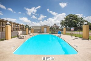 A swimming pool with a 5 ft no diving sign, a gazebo, and a fenced area with lounge chairs. - Days Inn by Wyndham Tallulah (Tallulah)