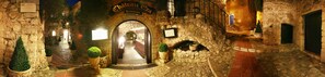 An entrance to Chateau Oza, a stone building with a sign indicating it is a restaurant.