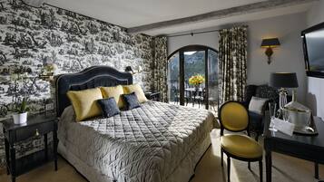 Un dormitorio con una cama grande, un escritorio con lámpara, una silla y vistas al exterior a través de una ventana.