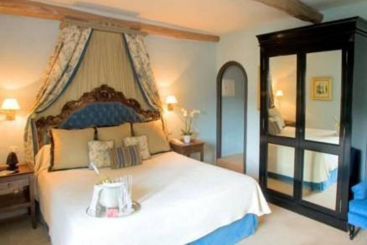 A bedroom with a bed, bedside tables, a mirror, and a window.