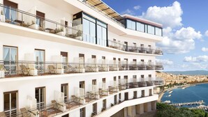 A multi-story hotel with balconies overlooking a marina and a coastal cityscape. - Hotel Paradiso, BW Signature Collection (Naples)