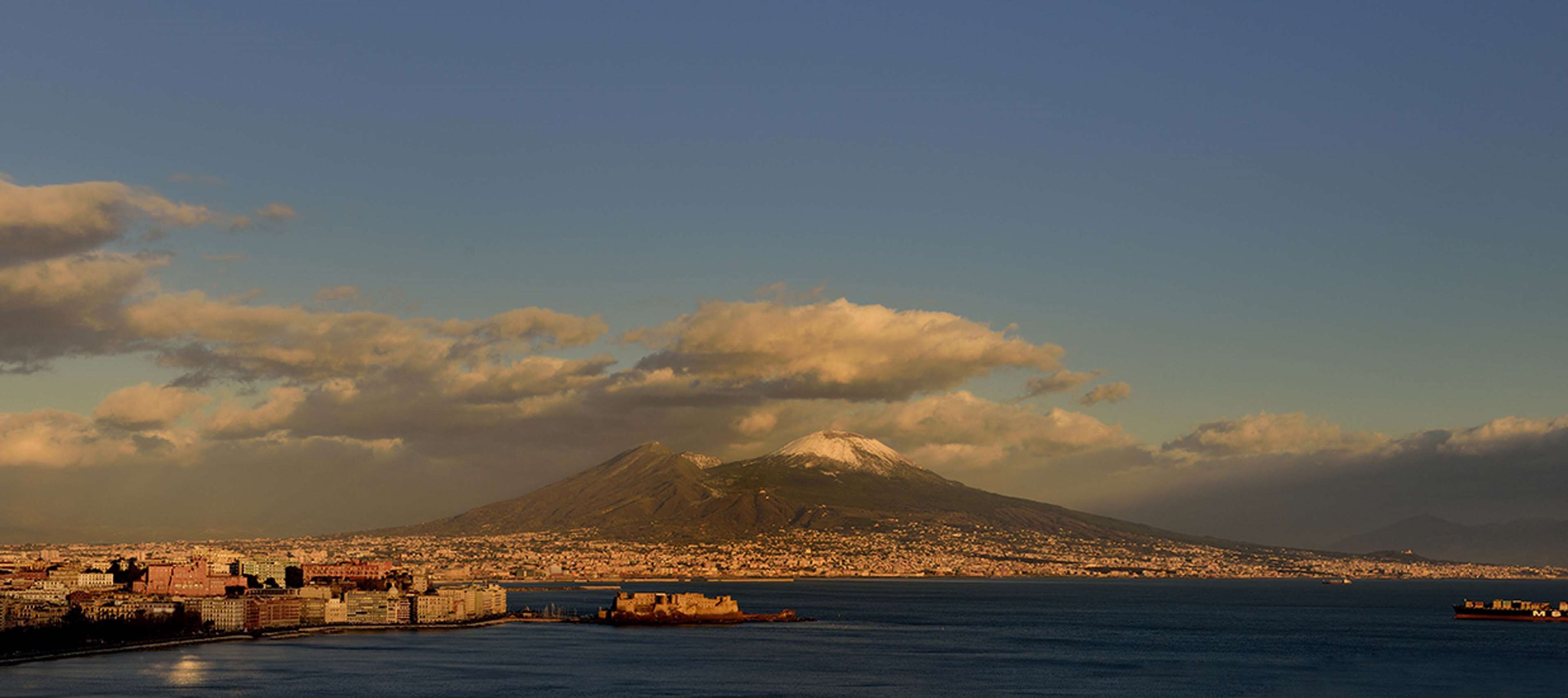 A coastal cityscape with a prominent mountain in the background.