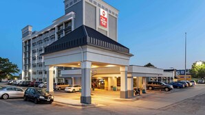A hotel with a modern design, featuring a prominent sign for 'Bee Western Plus'.