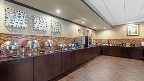 A buffet area with a variety of food stations, including a coffee station and a beverage dispenser.