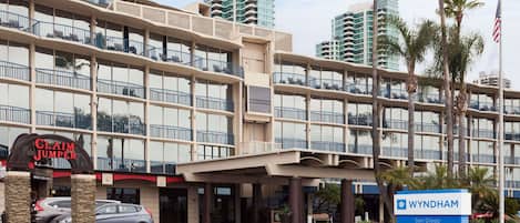 A multi-story hotel with a prominent 'Claim Jumper' sign, a 'Wyndham' sign, and a parking area with cars.