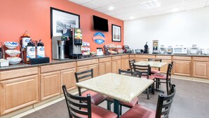 Un espace pour le petit-déjeuner comprenant un comptoir, des sièges et des appareils de cuisine.