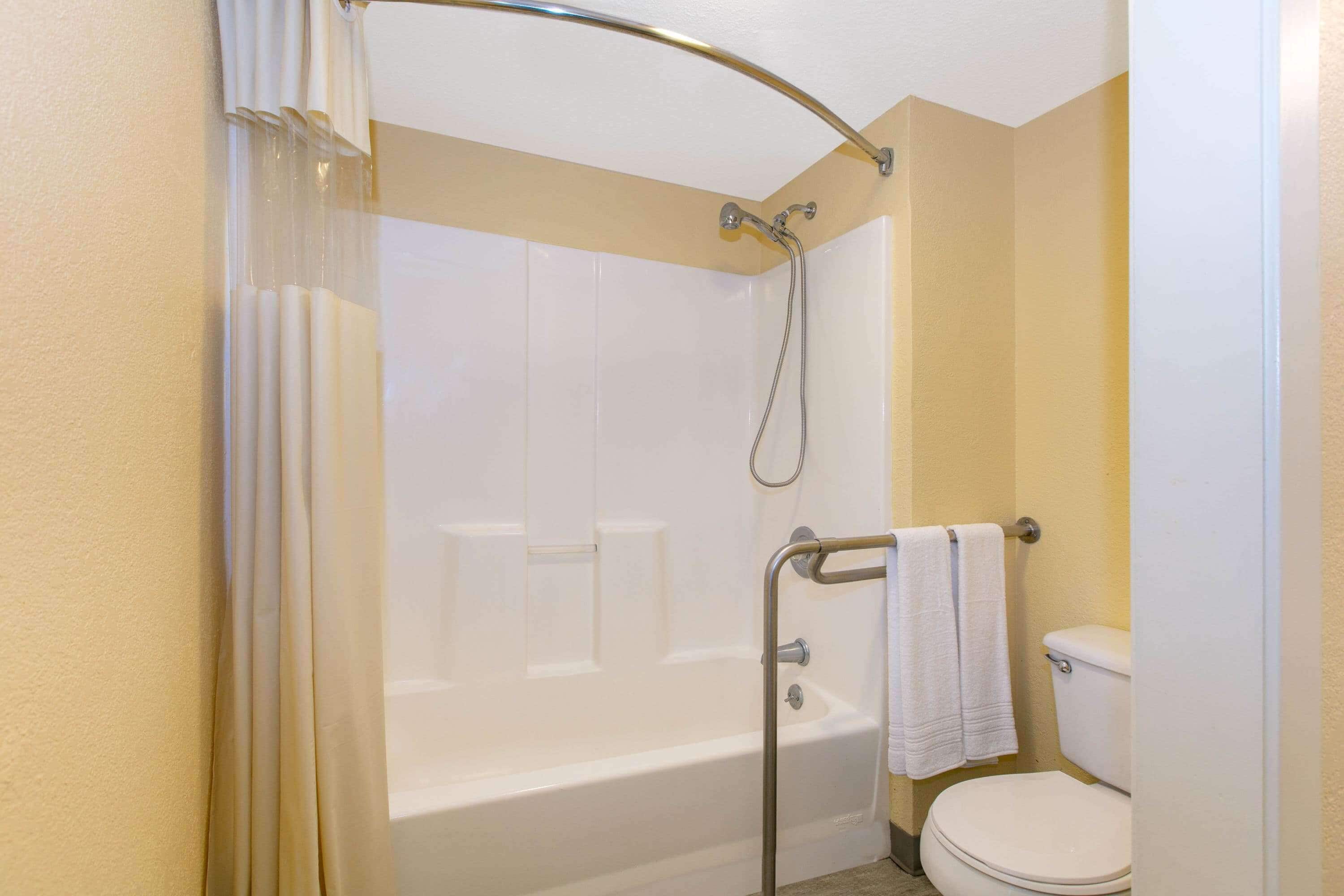 A bathroom with a bathtub, shower, and toilet.