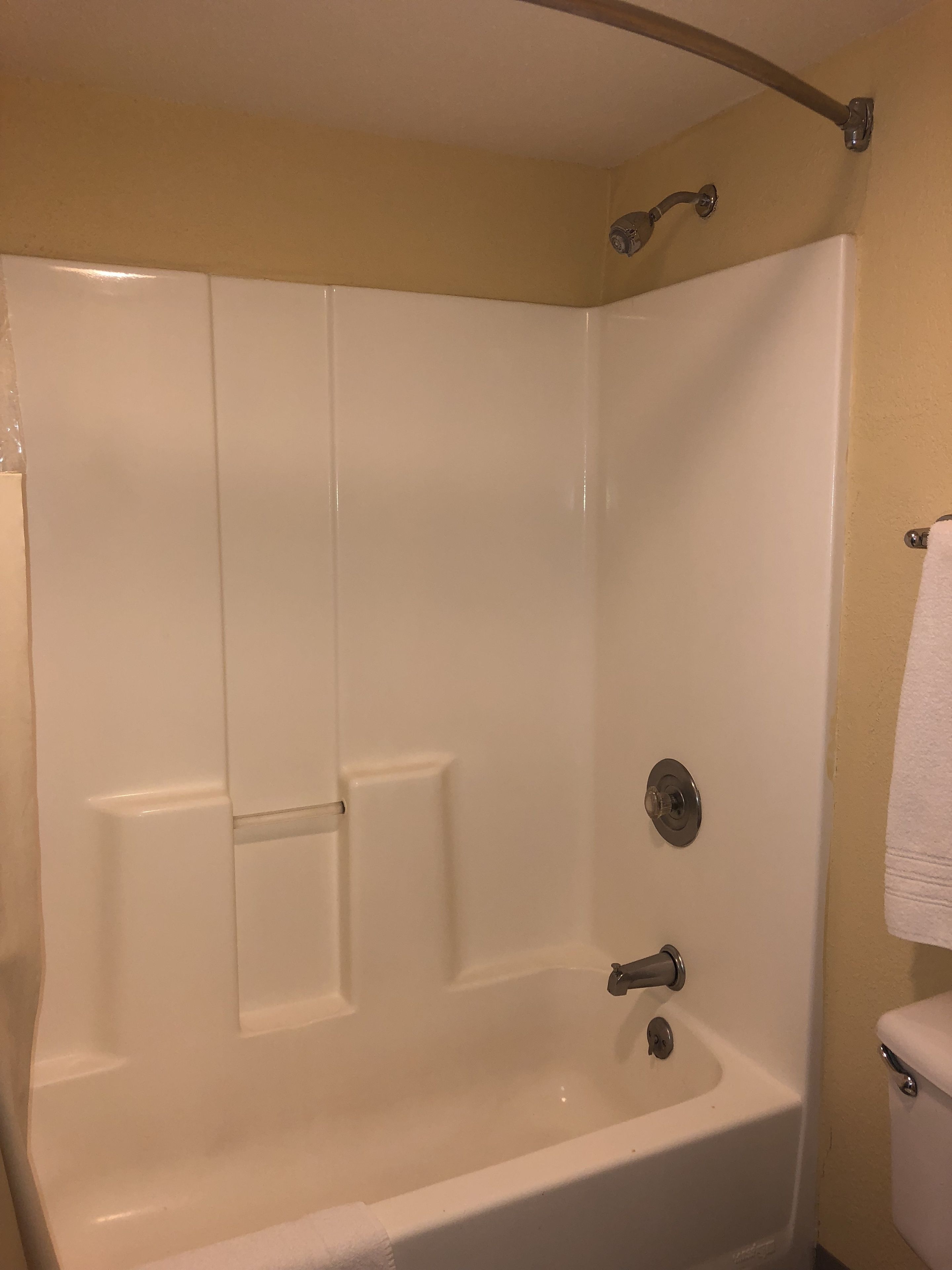 Une salle de bain standard équipée d’une baignoire, de toilettes et d’un rideau de douche.