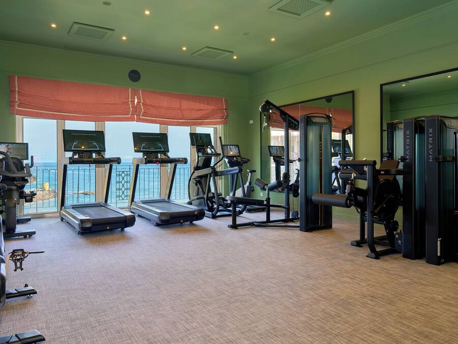 Een sportschool met loopbanden, gewichtapparaten en trainingsapparatuur.