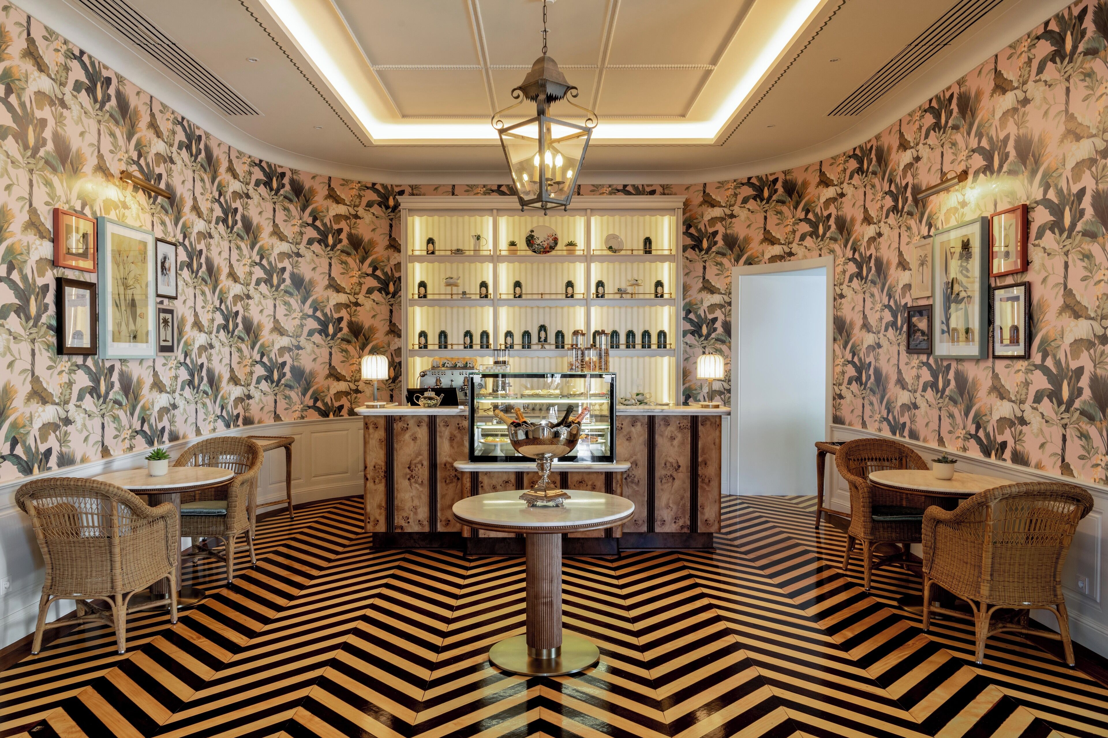 A room with a patterned floor, a central bar area with shelves, and wicker furniture.