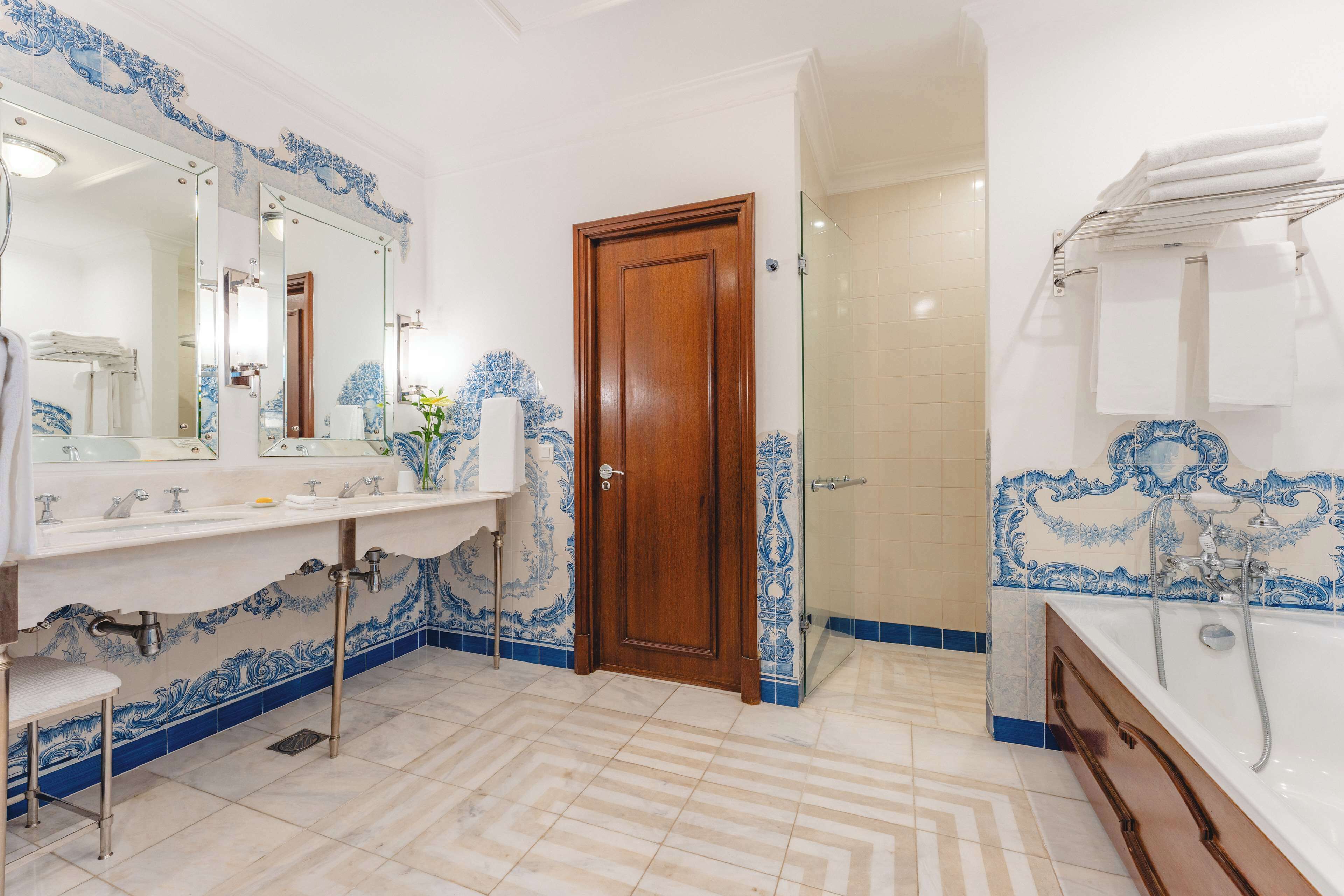 Un bagno con porta in legno, un lavandino con specchio e una vasca da bagno.