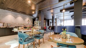 A modern restaurant with round tables, blue upholstered chairs, and a ceiling with intricate patterns. - The Raphael Vienna Hotel, a member of Radisson Individuals Boutique (Vienna)